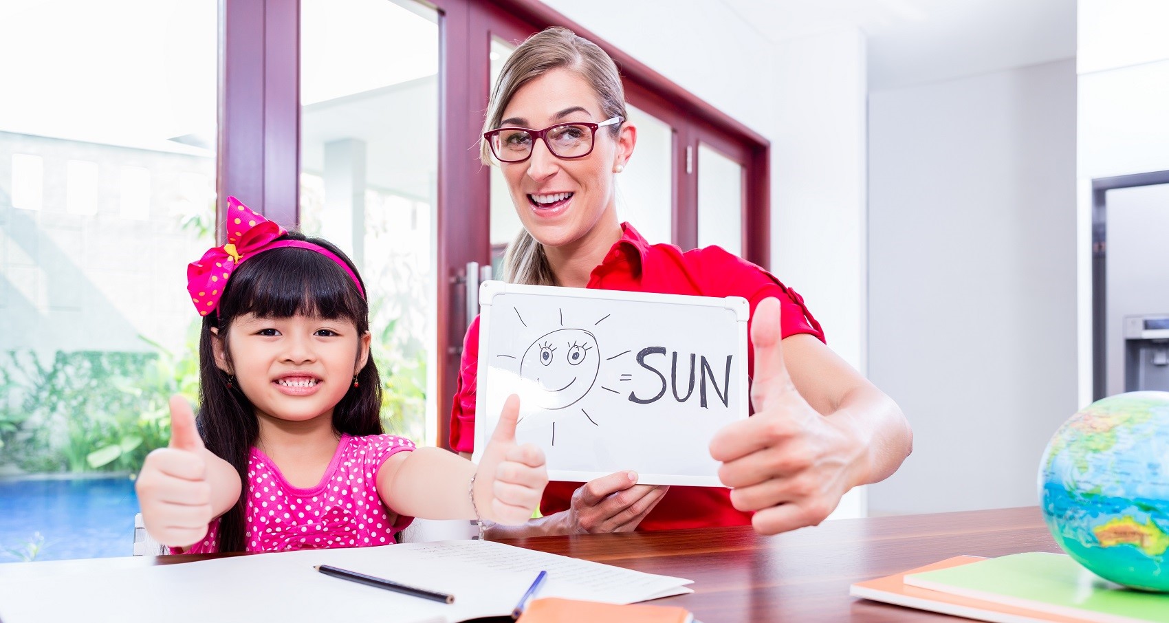 Teacher showing flashcard of sun to Chinese student