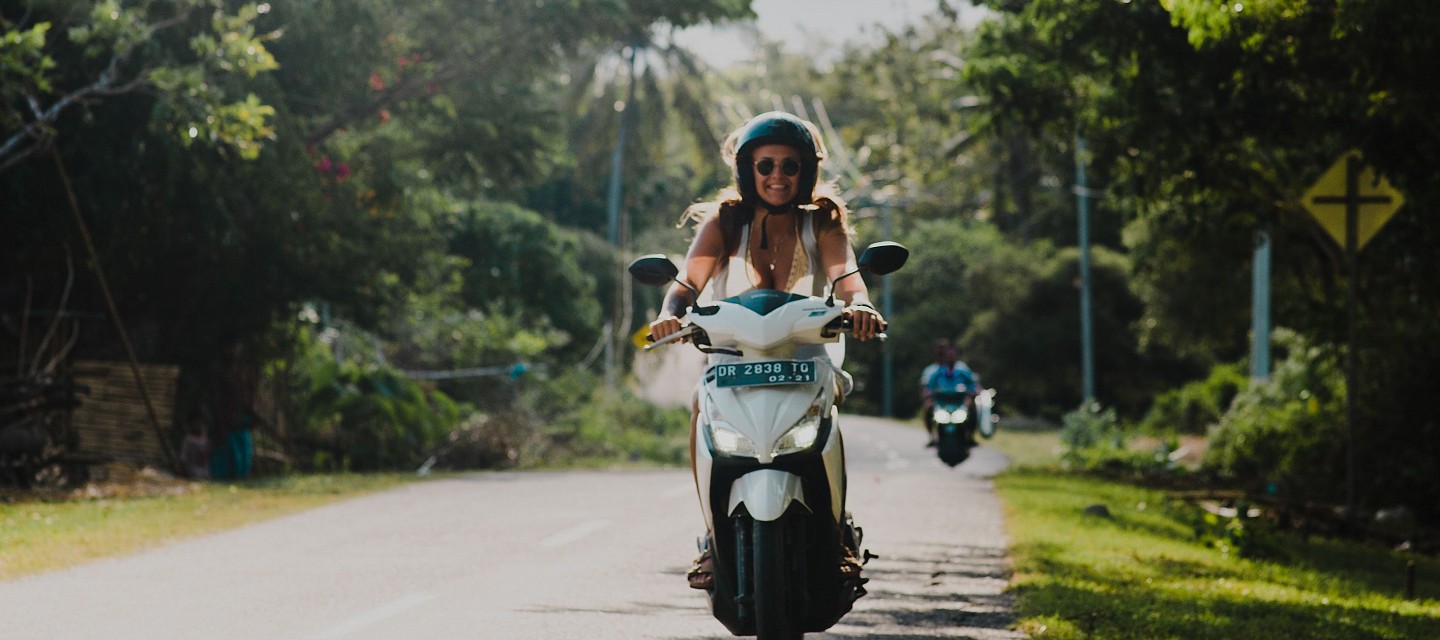 girl riding moped in rural indonesia