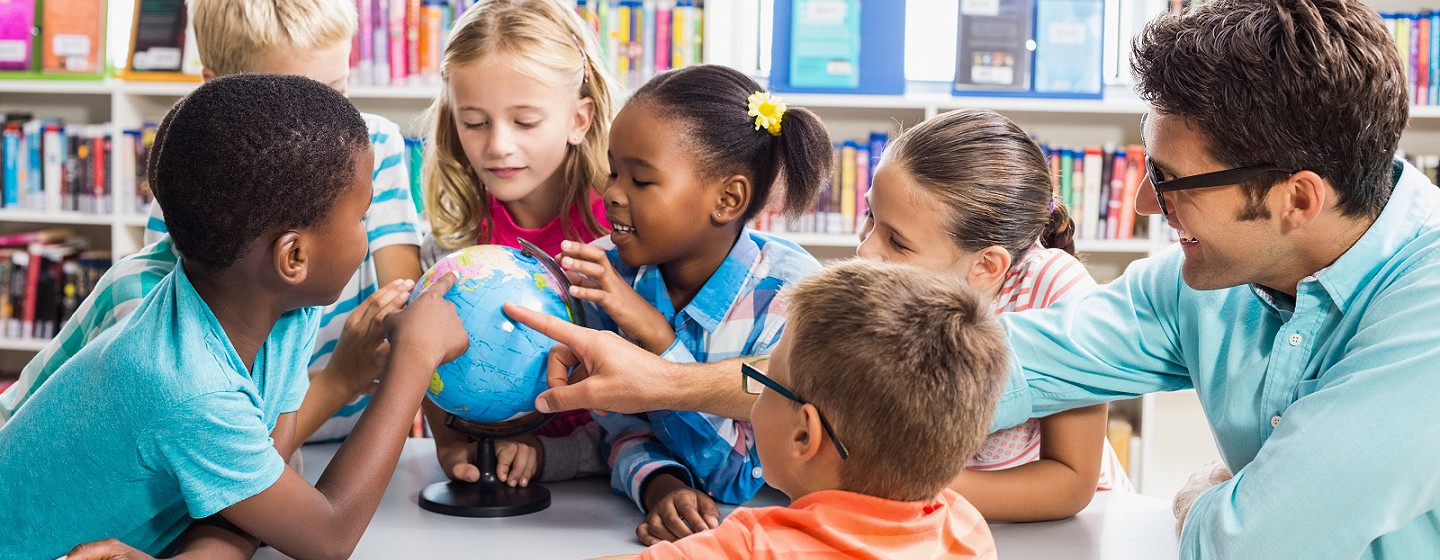 School kids looking at a globe